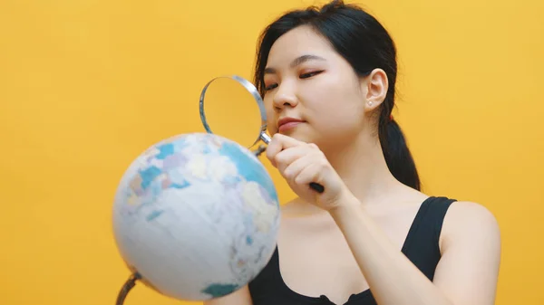 Jovem mulher asiática espião, segurando globo e lupa. Inquérito e inspecção — Fotografia de Stock