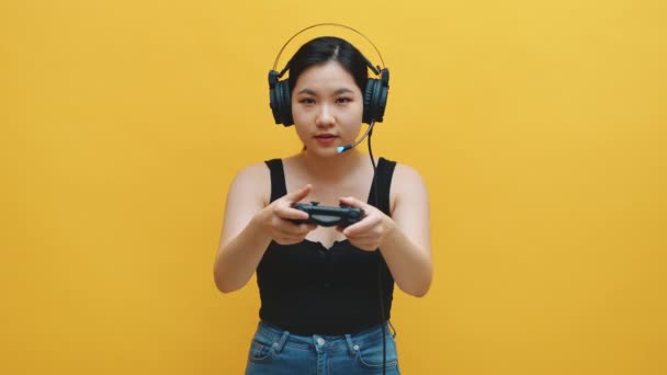 Joueur professionnel, jeune fille asiatique avec casque et joystick jeu vidéo gagnant — Video