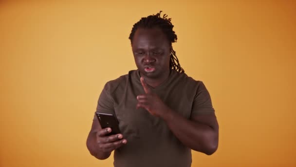 Hombre negro afroamericano joven con teléfono inteligente que tiene un secreto. Concepto de marido infiel — Vídeo de stock
