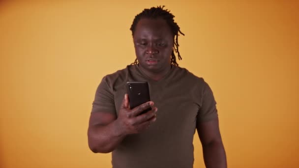 Choqué homme noir afro-américain lisant un message texte sur le smartphone — Video