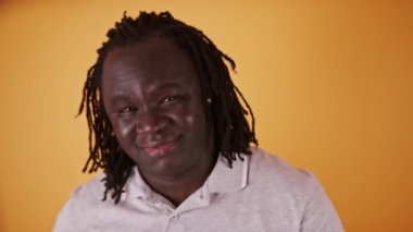 Genç, mutlu Afro-Amerikan siyahi adamın portresi örgülü saçlarını okşuyor.