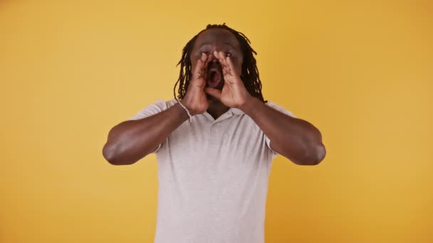 Černoch z Afriky dělá gesto na šálky a volá někoho s rukama kolem úst. zpomalený pohyb — Stock video