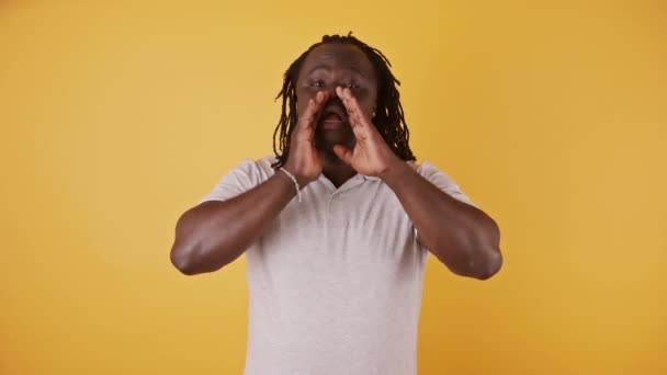 Afrika kökenli Amerikalı siyahi adam, elleri ağzında olan birini çağırarak kupa hareketi yapıyor. yavaş çekim — Stok video