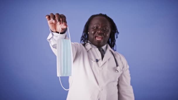 Egyszer használatos orvosi arcmaszk eldobása. Afrikai-amerikai fekete orvos rázza a fejét, és dobja el a maszkot — Stock videók