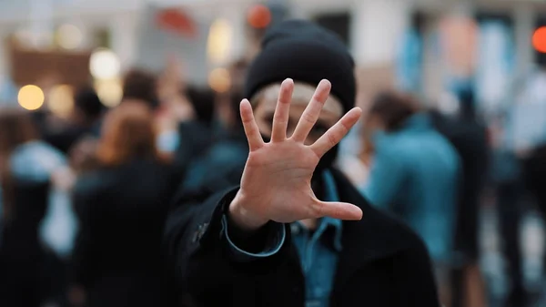 Sluta nu. Ung kvinna med ansiktsmask stoppande kamera med utsträckt hand. Demonstation och protest — Stockfoto