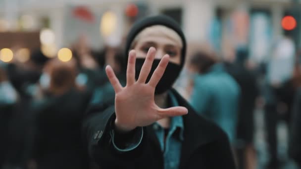 Hagyd abba! Egy fiatal nő arcmaszkkal, aki kinyújtott kézzel állítja le a kamerát. Demonstation és tiltakozás — Stock videók