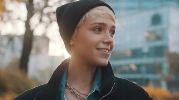 Portret młodej uśmiechniętej kobiety w czarnym kapeluszu i kurtce zimowej w mieście — Wideo stockowe