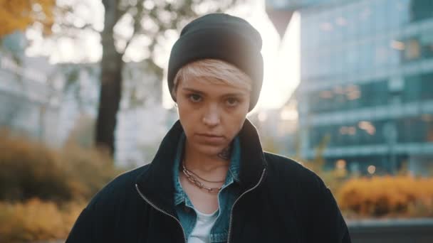 Портрет блондинки в зимней шляпе и пиджаке, смотрящей на камеру сердито — стоковое видео
