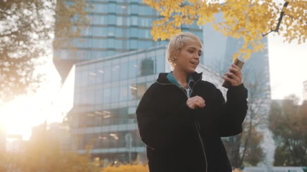 Ja gebaar. beurshandelaar. Jonge opgewonden gelukkige vrouw uiten winnende gebaar in het stadspark, terwijl het houden van smartphone — Stockvideo