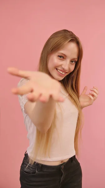 Portrait of young caucasian woman with hand reaching towards camera. Selective focus — Stock Photo, Image