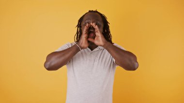 Elleri ağzında bir şey anons eden siyah bir adam.