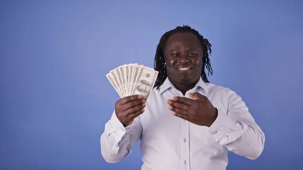 Genç Afrikalı Amerikalı adam elinde para tutuyor. Zenginlik kavramı — Stok fotoğraf