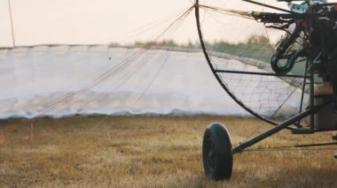 Kapatın. Paramotor 'un pervanesi dönüyor. Uçmaya hazırlanıyorum. Arkaplanda paraşüt.
