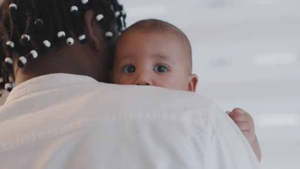 Небайдужий афроамериканський батько надувається зі своєю новонародженою дитиною. Концепція багаторасової сім'ї — стокове відео