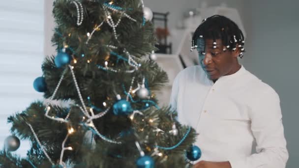 크리스마스 정신. 크리스마스 트리 장식하면서 노래하는 아프리카 흑인 남자 행복 — 비디오