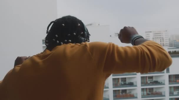 Hombre negro afroamericano feliz con auriculares bailando en la terraza — Vídeo de stock