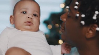 Çok ırklı güzel bir aile. Genç siyah baba yeni doğmuş bebeğini kucağında tutuyor. Kapat.