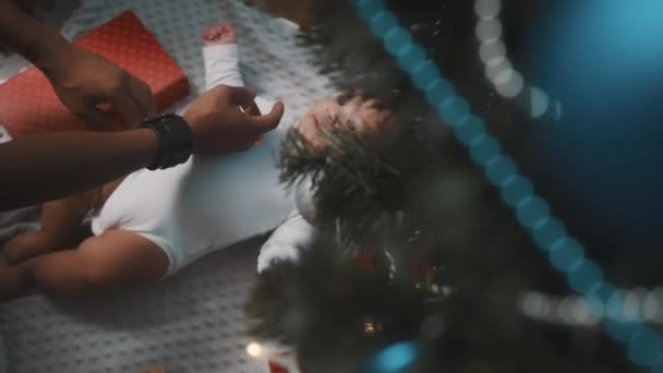 Prima il Natale del bambino. Papà e neonato giocano sotto l'albero di Natale decorato — Video Stock