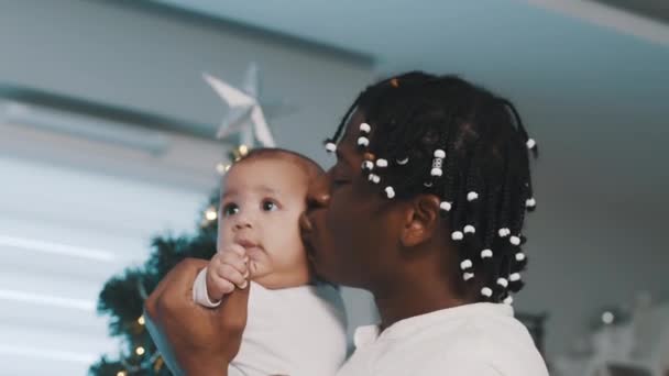 Kerstmis in multiraciale familie. Afro-Amerikaanse vader dansen en kussen zijn baby — Stockvideo