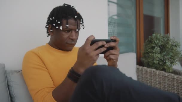 Retrato de homem negro afro-americano focado jogando jogos no smartphone — Vídeo de Stock