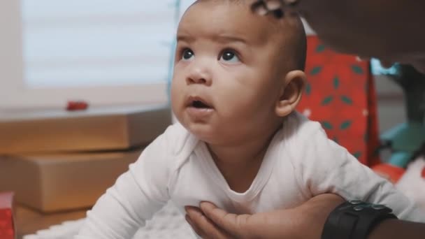 Papai brincando com seu bebê adorável na frente da árvore de Natal. Presentes em segundo plano — Vídeo de Stock