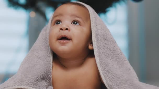Adorable mulatto baby covered with towel having fun tummy time — Stock Video