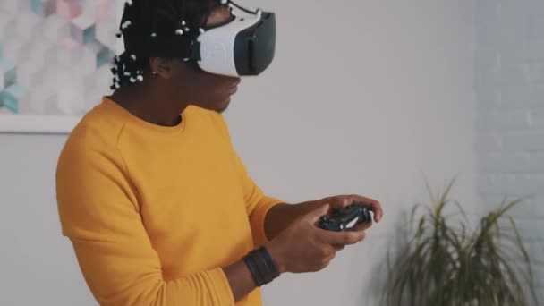 Realidad virtual, hombre negro africano con gafas VR usando mando a distancia y jugando juegos — Vídeos de Stock