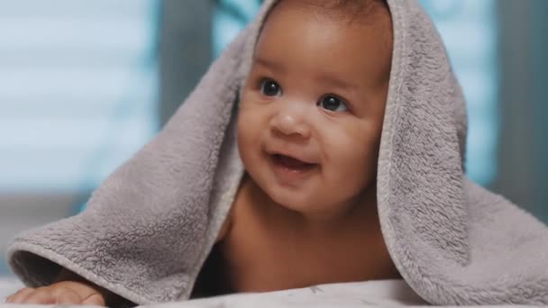 Adorável pele escura bebê coberto com toalha se divertindo barriga tempo — Vídeo de Stock