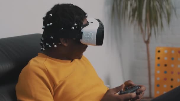 Virtuální realita, africký černoch s VR sluchátky pomocí dálkového ovladače a hraní her — Stock video