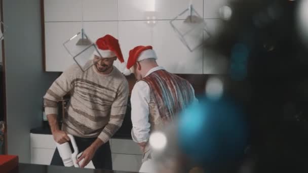Gelukkig man gay paar schoonmaken keuken en voorbereiding voor kerst avond — Stockvideo