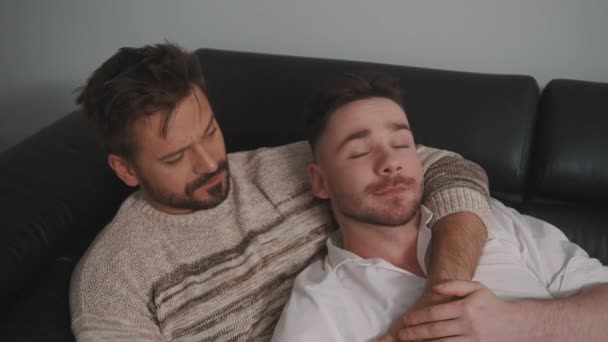 Casal gay romântico jovem abraçando e relaxando no sofá. Conceito de estilo de vida familiar diferente Amor e cuidado — Vídeo de Stock