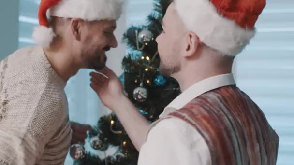 Couples homosexuels masculins attrayants célébrant le Nouvel An, décorant ensemble l'arbre de Noël. Bonne famille profitant des vacances — Video