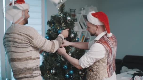 Ομοφυλόφιλο αντρικό ζευγάρι στολίζει χριστουγεννιάτικο δέντρο — Αρχείο Βίντεο
