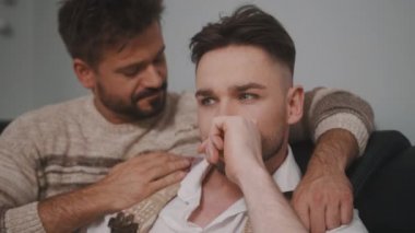 Haberler kötü. Adam neredeyse ağlayan ortağını sakinleştiriyor.