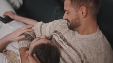 Sevgililer kanepede birlikte dinleniyor. Yakışıklı bir adam kocasının kucağında başını dinlendiriyor..