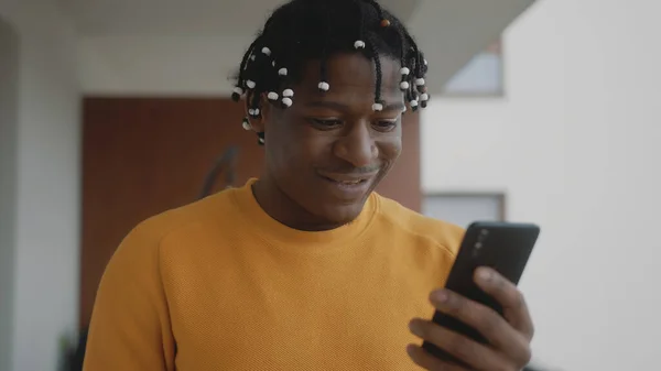 Retrato del hombre negro afroamericano recibiendo una buena noticia. Lectura de texto en el smartphone con gesto ganador — Foto de Stock