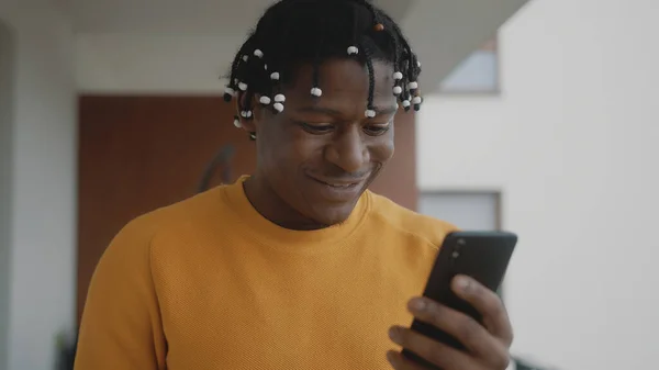 Retrato del hombre negro afroamericano recibiendo una buena noticia. Lectura de texto en el smartphone con gesto ganador — Foto de Stock