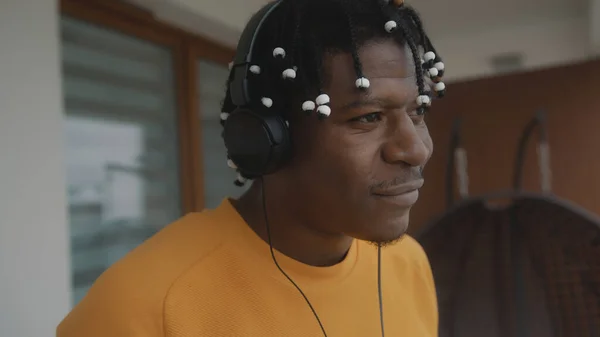 Portret van Afro-Amerikaanse zwarte man met dreadlocks die met een headset naar de muziek op het balkon luisteren — Stockfoto