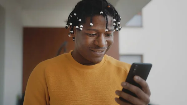 Hombre negro afroamericano recibiendo una buena noticia. Lectura de texto en el smartphone — Foto de Stock