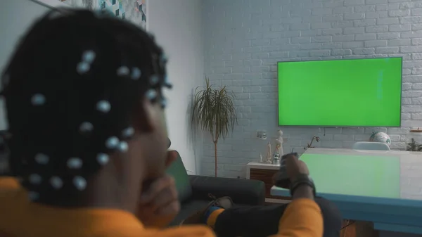 Afro-Amerikaanse zwarte man kijken naar grote groene tv-scherm — Stockfoto