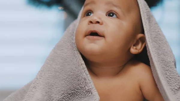 Close up of cute black baby with head covered with fluffy towel — Stock Photo, Image