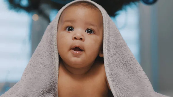 Adorável pele escura bebê coberto com toalha se divertindo barriga tempo — Fotografia de Stock