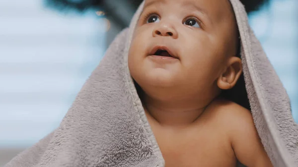 Havluyla kaplanmış sevimli siyah tenli bebek göbek zamanı eğleniyor. — Stok fotoğraf