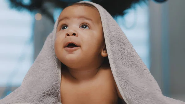 Havluyla kaplanmış sevimli siyah tenli bebek göbek zamanı eğleniyor. — Stok fotoğraf