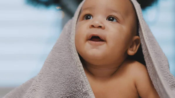 Entzückende dunkle Haut Baby mit Handtuch bedeckt Spaß Bauch Zeit — Stockfoto