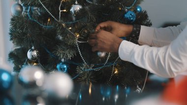 Yakın plan, Noel ağacı süslemesi. Afrikalı Amerikalı siyahi adam Noel ağacını süslüyor.