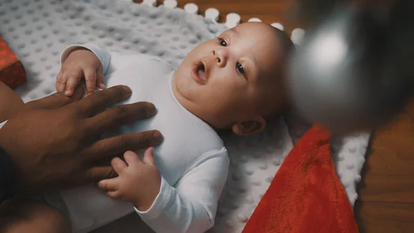 İlk Noel 'de bebek. Baba ve yeni doğan süslemeli Noel ağacının altında oynuyorlar. — Stok fotoğraf