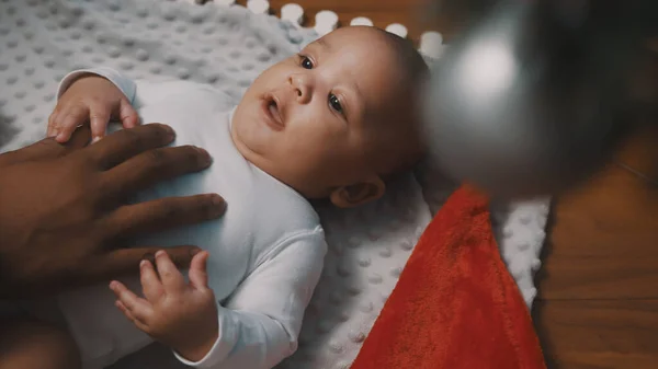 İlk Noel 'de bebek. Yeni doğmuş bebek, babasıyla oynarken Noel ağacı süslemesine hayran. — Stok fotoğraf