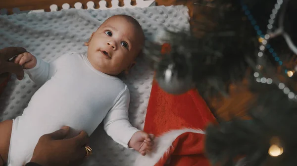 İlk Noel 'de bebek. Baba ve yenidoğan oyun oynarken kırmızı hediye kutuları alırlar. Karışık ırk ailesi — Stok fotoğraf