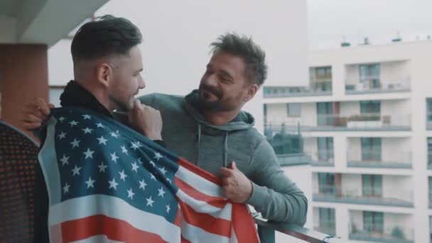 행복하게 잘 생긴게 이 커플 발코니에서 미국 국기 아래껴안고 — 비디오